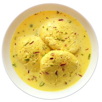 A white bowl filled with saffron-infused ras malai, topped with nuts and rose petals